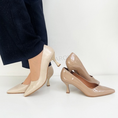 Dois pares de sapatos de salto médio em tons de bege sobre fundo branco.