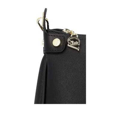 Detalhe de uma mala preta com ornamento metálico e botão dourado