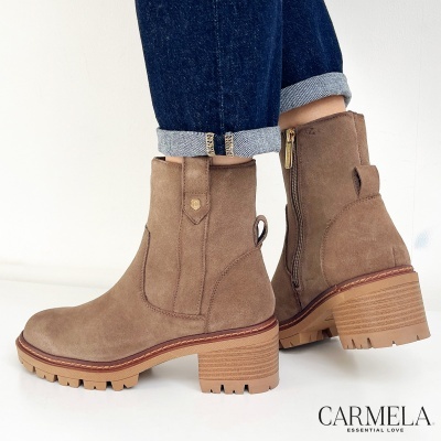 Botas de cano curto castanhas em camurça com salto grosso de madeira e fecho lateral, usadas com calças de ganga