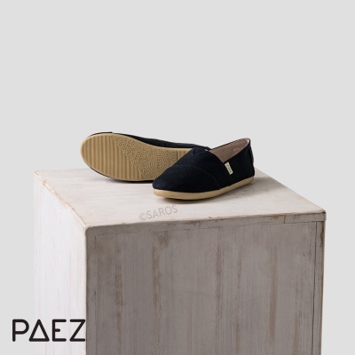 Sapatos alpercatas pretos com sola bege sobre caixa de madeira branca