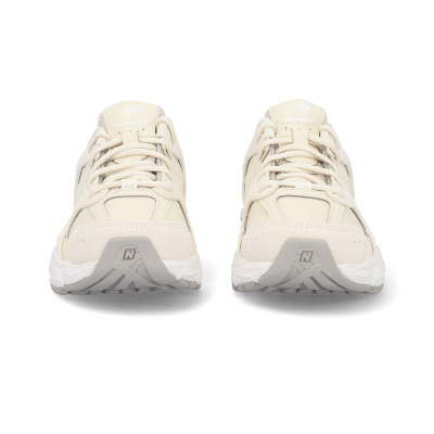Ténis de corrida New Balance bege claro vistos de frente