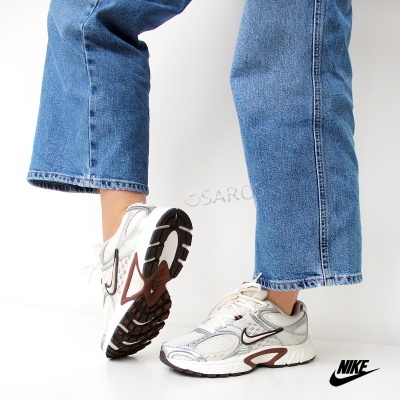 Ténis desportivos brancos Nike com detalhes em cinza e castanho e sola preta e branca