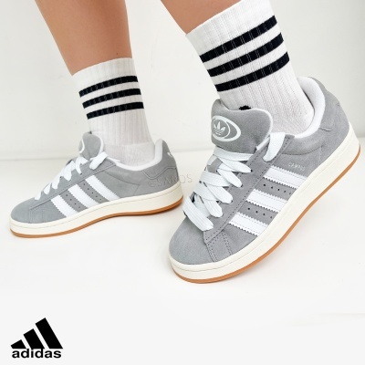 Ténis Adidas cinzentos com riscas brancas e meias brancas com riscas pretas