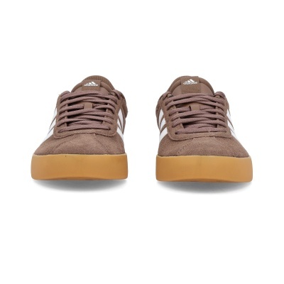 Sapatilhas Adidas castanhas em camurça com riscas brancas e sola castanha clara.