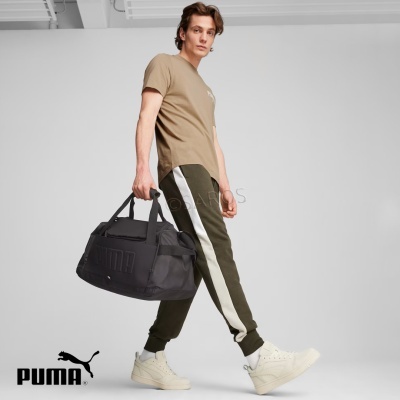 Homem com saco desportivo preto e roupa desportiva sobre fundo branco.