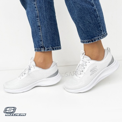 Sapatilhas Skechers brancas com detalhes cinza usadas com jeans azul.
