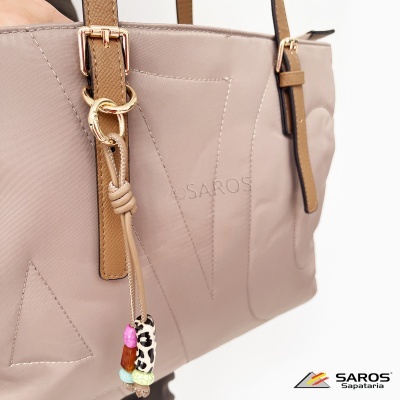 Mala bege com detalhes castanhos e pendente colorido