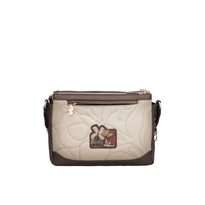 Mala de tiracolo bege com detalhes castanhos e patch decorativo com moinho