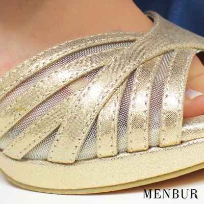 Sandália dourada com tiras cruzadas e texto MENBUR