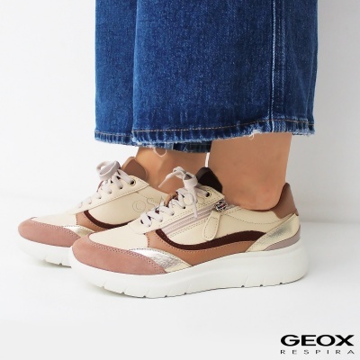 Ténis Geox creme com rosa e castanho, com sola branca e fecho lateral em modelo com calças de ganga