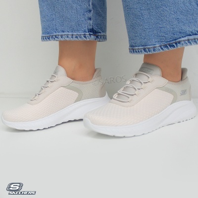 Ténis Skechers bege e branco com detalhe cinzento e calças de ganga azuis
