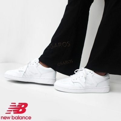 Sapatilhas desportivas brancas New Balance usadas por uma pessoa com calças pretas