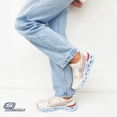 Ténis Skechers bege com sola azul usados com calças de ganga