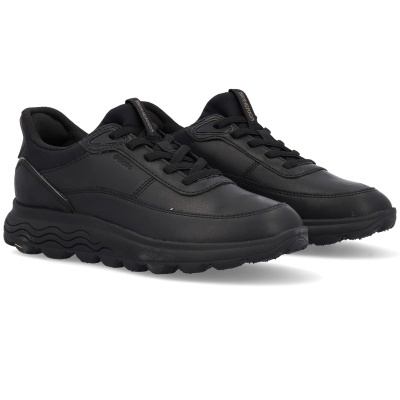 Sapatilhas pretas com sola ondulada em fundo branco