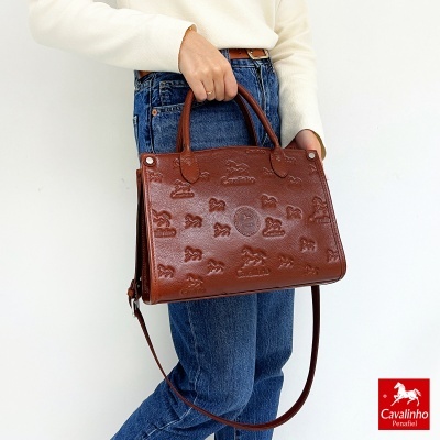 Mala de mão castanha em pele com padrão de cavalos em relevo e logótipo Cavalinho Portugal