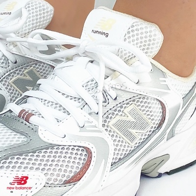 Tênis New Balance de corrida branco e cinza com detalhes vermelhos