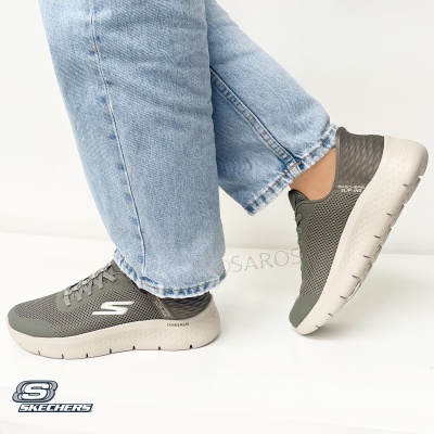 Ténis Skechers cinzentos com sola branca e calças de ganga azuis