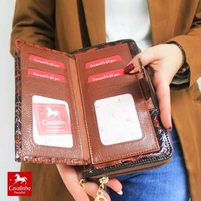 Carteira em pele castanha com padrão de pele de cobra e detalhes vermelhos com texto.