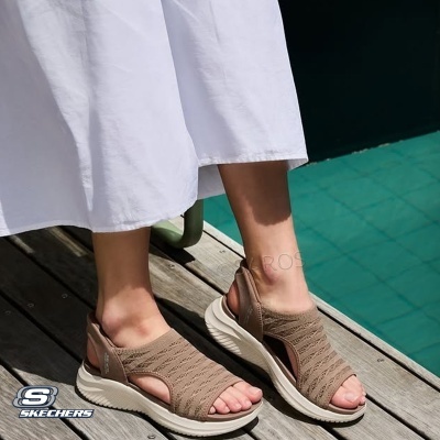 Sandálias bege Skechers com sola branca usadas perto de piscina