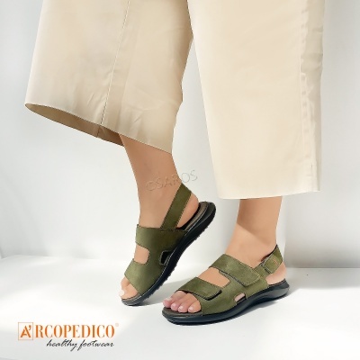 Sandálias verdes com velcro em pele e sola preta com calças bege claras