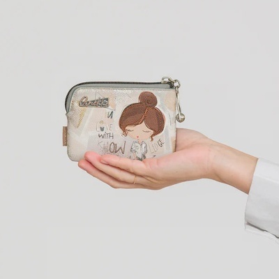 Carteira pequena com fecho, padrão bege e castanho, desenho de menina e texto Anekke