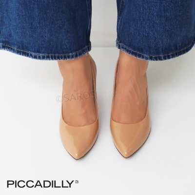 Sapatos de verniz bege com bico fino usados com jeans azuis