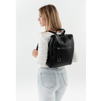 Mochila preta de couro sintético com fecho frontal usada por mulher