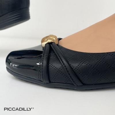 Sapato preto com biqueira verniz e detalhe dourado usado no pé