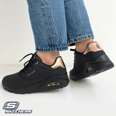 Ténis pretos Skechers com detalhes dourados e sola preta