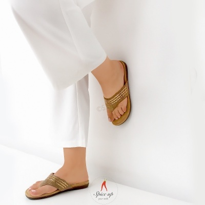 Chinelos dourados com franjas usados com calças brancas