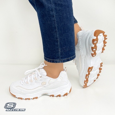 Ténis Skechers brancos com sola castanha usados com calças de ganga