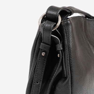 Detalhe de mala preta em pele com alça ajustável e argolas metálicas