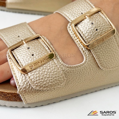 Sandália dourada com duas fivelas douradas gravadas com texto, solado de cortiça