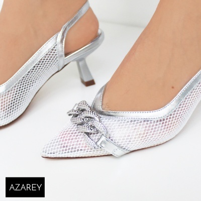 Sapatos prateados tipo slingback com corrente decorativa e salto médio em fundo branco.