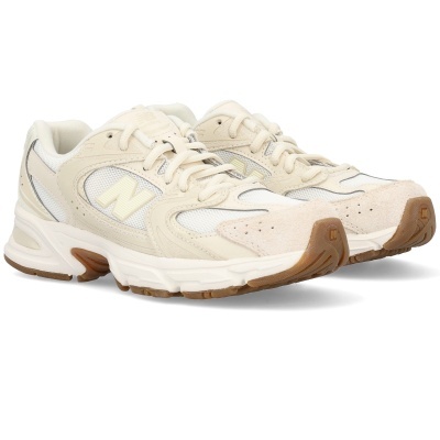 sapatilhas New Balance creme e branco com sola castanha e logo 'N' amarelo