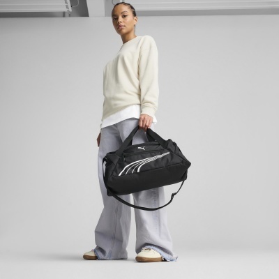 Mulher a segurar mala desportiva preta PUMA com alças, vestido casual