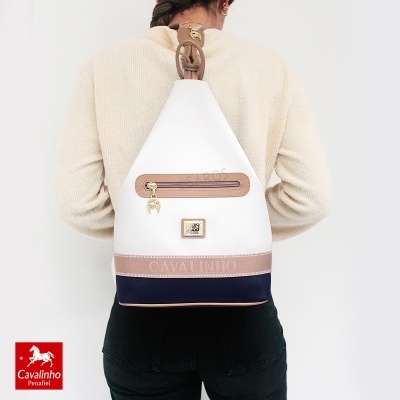 Mochila triangular branca, bege e azul escuro Cavalinho vista pelas costas