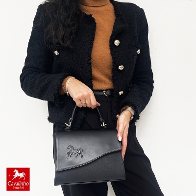 Mala de mão preta com logótipo de cavalo e roupa preta e castanha