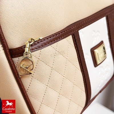 Bolsa bege com detalhes em pele castanha e fecho dourado com pendente VAR