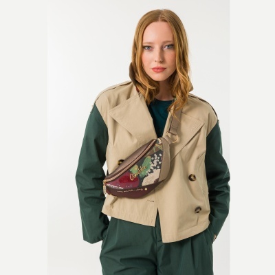 Mulher com casaco bege e verde escuro, bolsa estampada com padrão floral e texto Anekke
