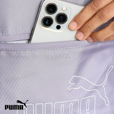 mão a colocar telemóvel com três câmaras numa bolsa lavanda com logótipo Puma branco