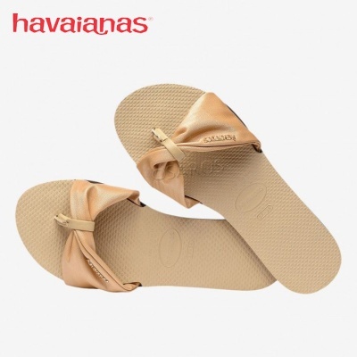 Chinelos Havaianas rosa claro com tiras largas em tecido acetinado e solado texturizado.