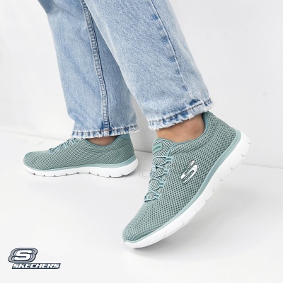 Ténis Skechers verdes de mulher com sola branca e jeans claros