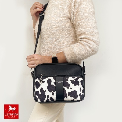 Mala tiracolo preta com padrão animal preto e branco e detalhe em pele