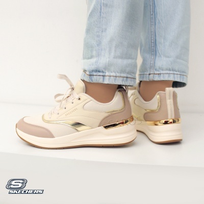 Sapatilhas Skechers bege com detalhes dourados e sola branca usadas com jeans