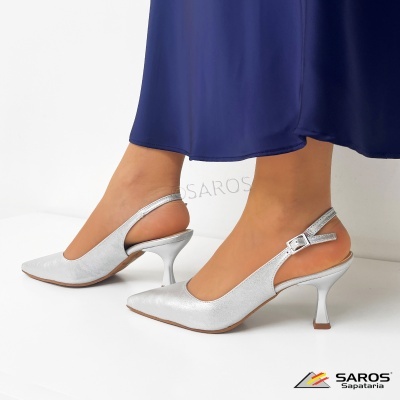 Sapatos de salto médio prateados com alça e fivela usados com vestido azul escuro