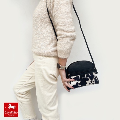 Mala pequena de ombro com padrão animal preto e branco e parte superior preta