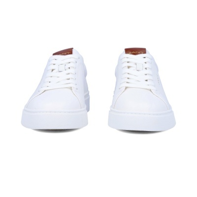 Ténis brancos com sola branca e etiqueta castanha com texto GANT