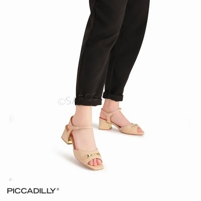 Sandálias femininas nude com salto médio dourado e detalhe metálico usadas com calças pretas