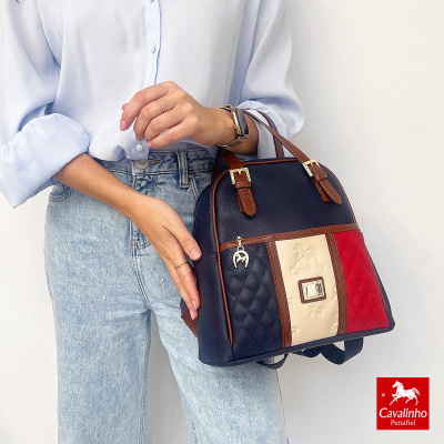 Mochila Cavalinho em couro sintético preto, creme e vermelho com ferragens douradas e pendente metálico